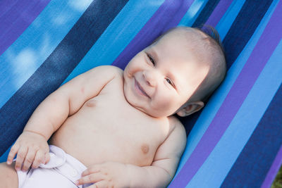 High angle view of baby lying on fabric