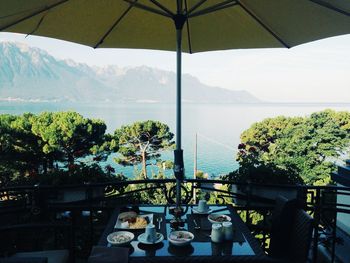 Food served on table by sea and mountains against sky