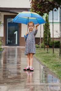 Rear view of woman with umbrella walking on footpath