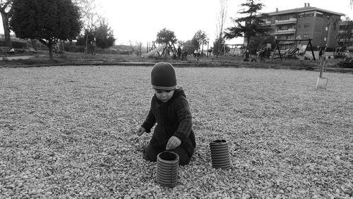 Boy playing with containers at playground