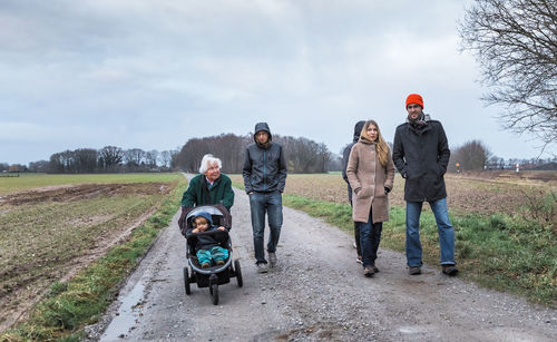Family on road against sky during winter