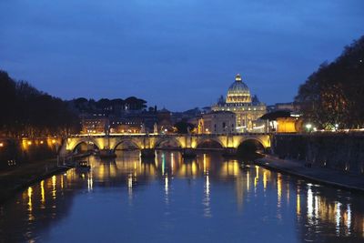 Illuminated bridge over river against sky at night