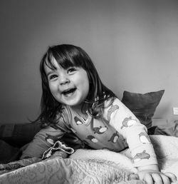 Portrait of smiling girl on bed at home