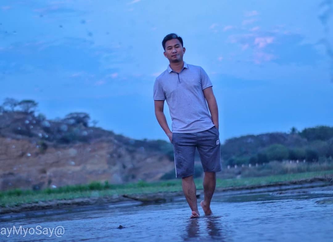 standing, real people, one person, lifestyles, front view, water, leisure activity, nature, casual clothing, young adult, young men, portrait, day, men, full length, blue, land, sky, outdoors, shorts