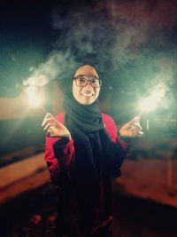 Portrait of smiling young woman standing in park