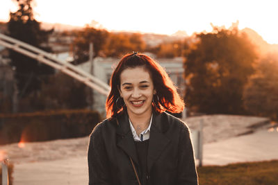 Portrait of smiling young woman standing outdoors