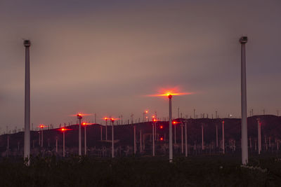 Illuminated street light against sky at sunset