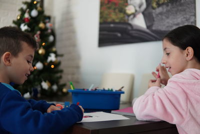 Rear view of mother and daughter on christmas tree