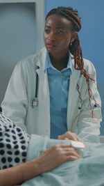 Portrait of doctor examining patient in clinic