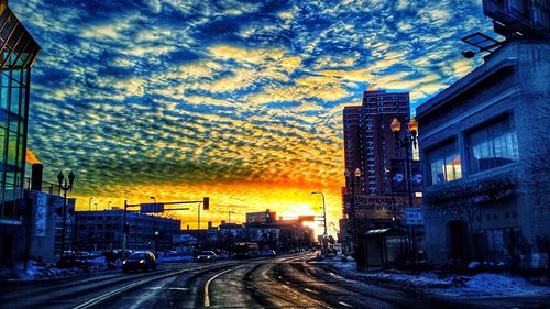 View of city street against cloudy sky