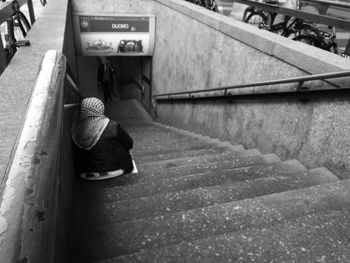 Rear view of a woman sitting on stairs
