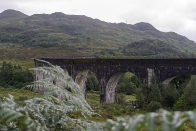 Arch bridge over river against sky