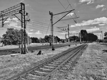 Railroad tracks by trees against sky