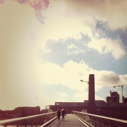 People walking in city against clear sky