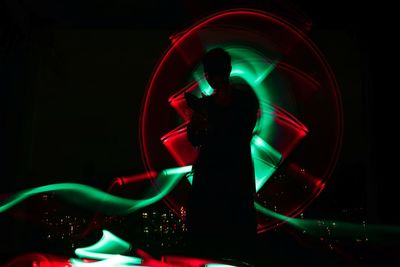 Man with light painting at night