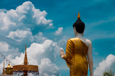 Low angle view of statue against temple building against sky