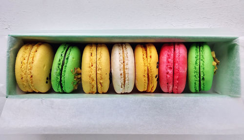 Directly above shot of colorful macaroons in box on table