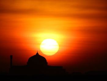 Silhouette building against sky during sunset