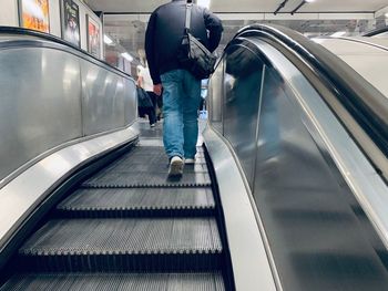 Rear view of man standing on escalator