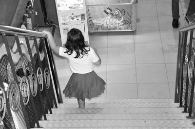 Rear view of woman walking on staircase