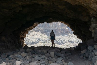 Rear view of man standing on rock