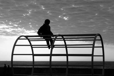 Rear view of silhouette man looking at sea against sky