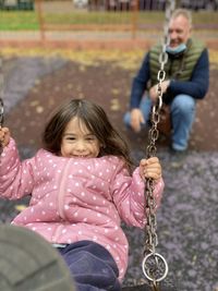 Portrait of girl sitting on swing