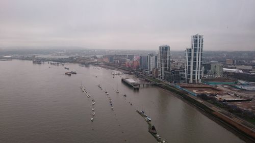 High angle view of river by cityscape against sky