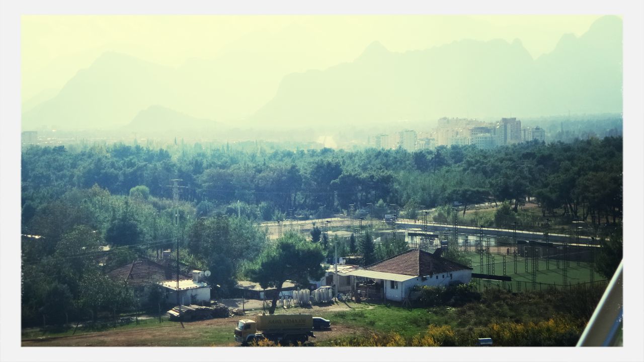 building exterior, tree, architecture, built structure, transfer print, high angle view, landscape, house, auto post production filter, mountain, sky, residential structure, residential district, residential building, city, cityscape, nature, growth, scenics, green color