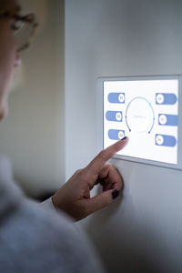 Woman using digital tablet on wall at modern home