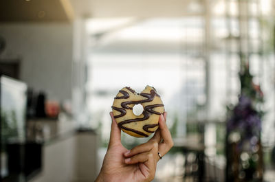 Cropped hand of woman holding donut