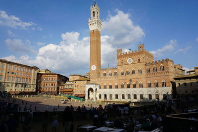 People at town square against sky in city