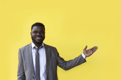 Portrait of smiling man against yellow background