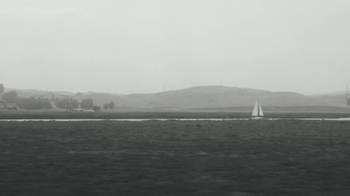 Sailboat sailing on sea against clear sky