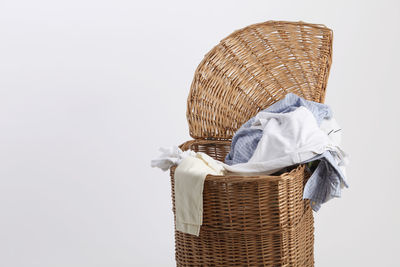 Close-up of clothes in laundry basket against white background