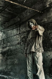 Man wearing mask against wall