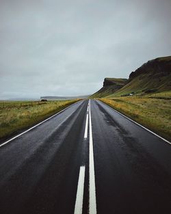 Empty road along countryside landscape