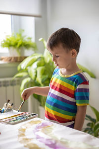 Portrait of boy looking away while sitting at home