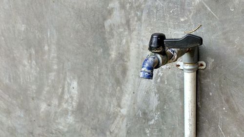 Close-up of faucet against wall