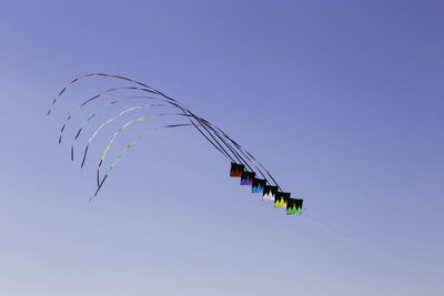 Low angle view of kite flying against clear blue sky