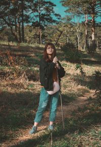 Portrait of young woman standing in forest