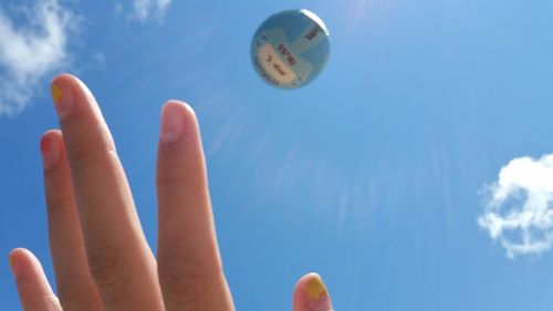 Low angle view of cropped hand against clear sky