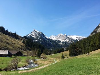 Scenic view of snowcapped mountains against blue sky