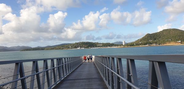 Panoramic view of footbridge over sea against sky