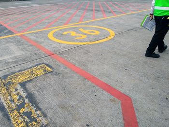 Low section of man inspecting airport runway