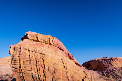 Low angle landscape of patterned pink and yellow stone boulder at valley of fire state park 