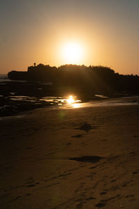 Scenic view of beach against sky during sunset