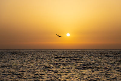 Scenic view of sea against orange sky