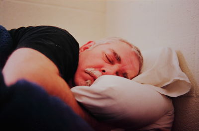 Close-up of man sleeping on bed