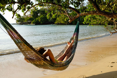 Woman resting in hammock at bench